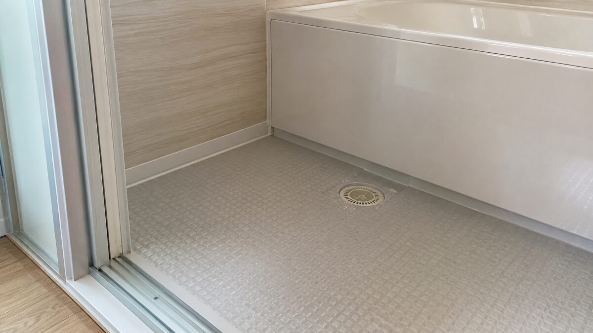 浴室の臭いが消えないときに排水口と床の隅と浴槽外側を確認する場面