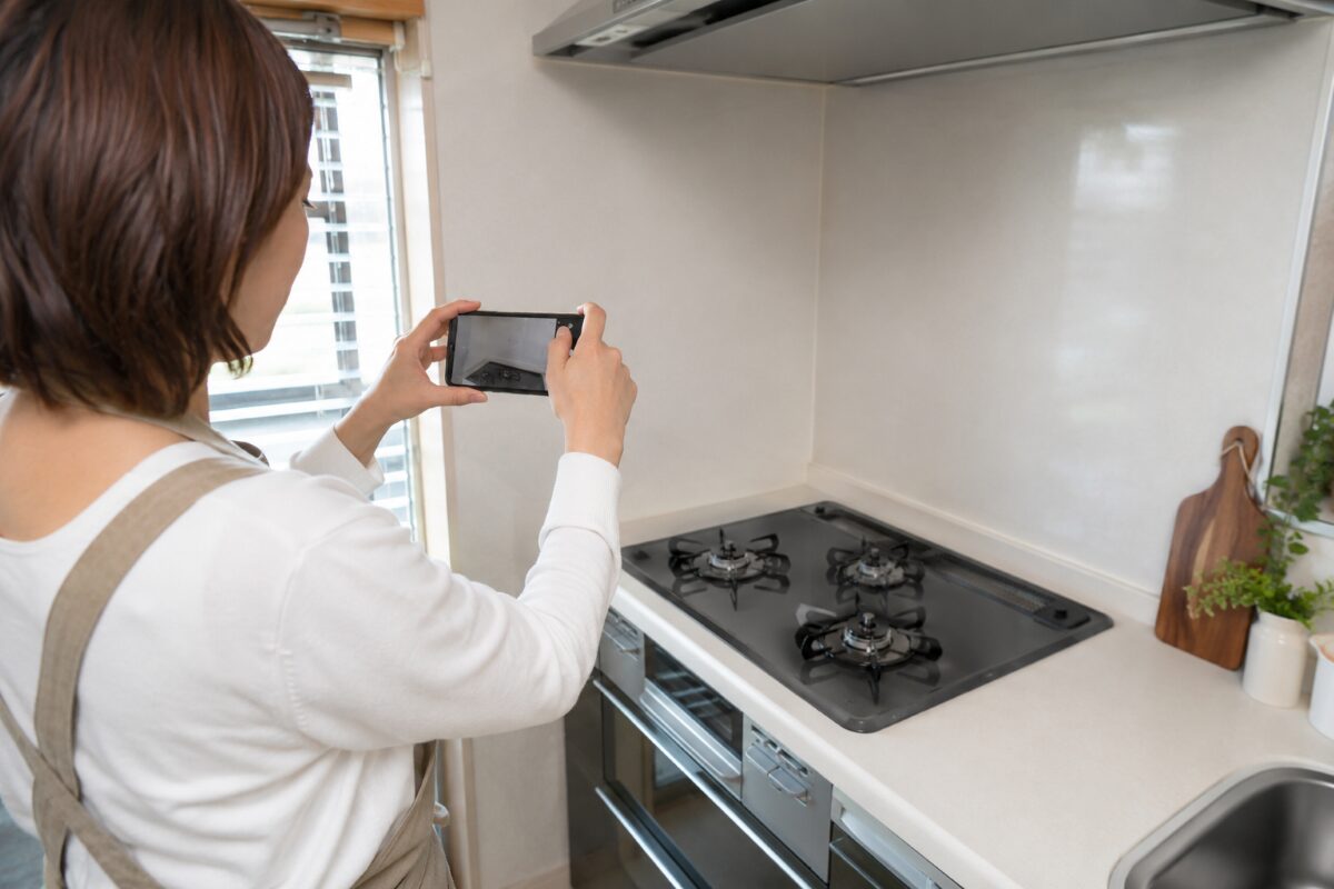 キッチンのベタつき箇所をスマートフォンで撮影して確認する様子