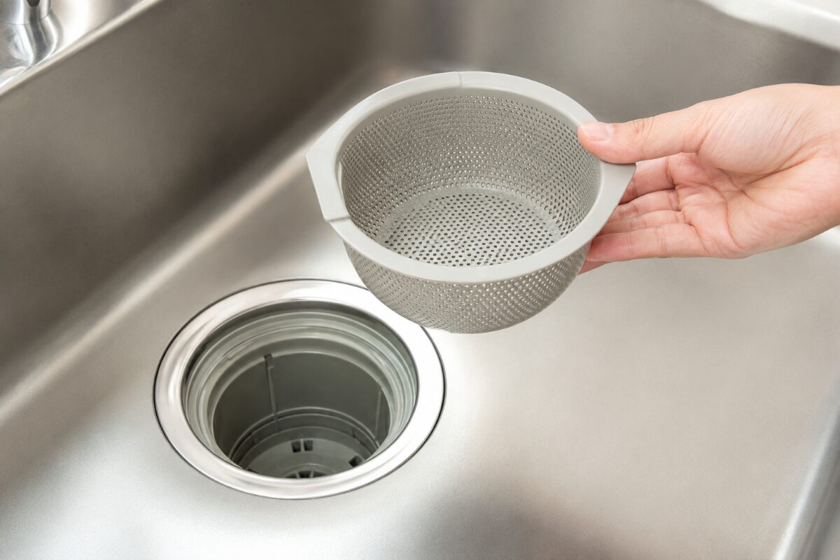 キッチン排水口の取り外せる部品を確認している様子