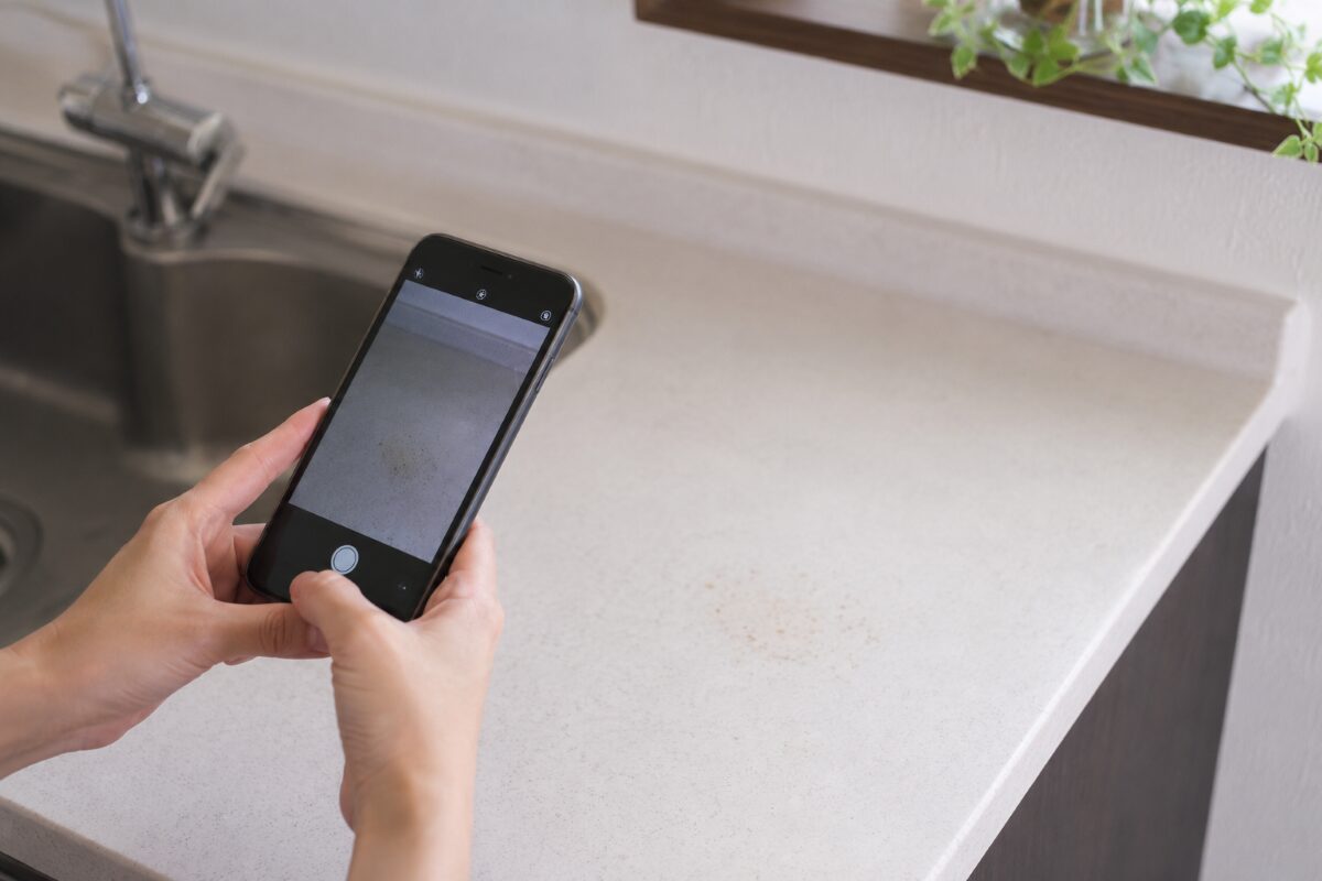 掃除しても変化が少ない箇所をスマートフォンで撮影している様子