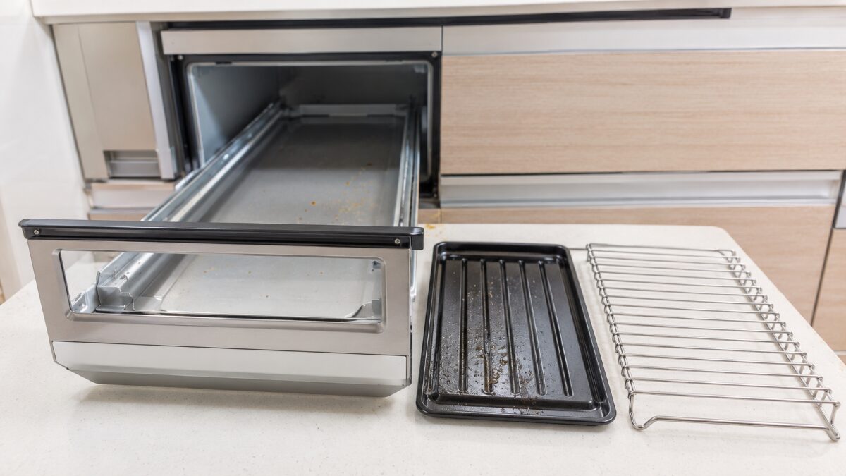魚焼きグリルの網と受け皿を外して部品を確認する様子