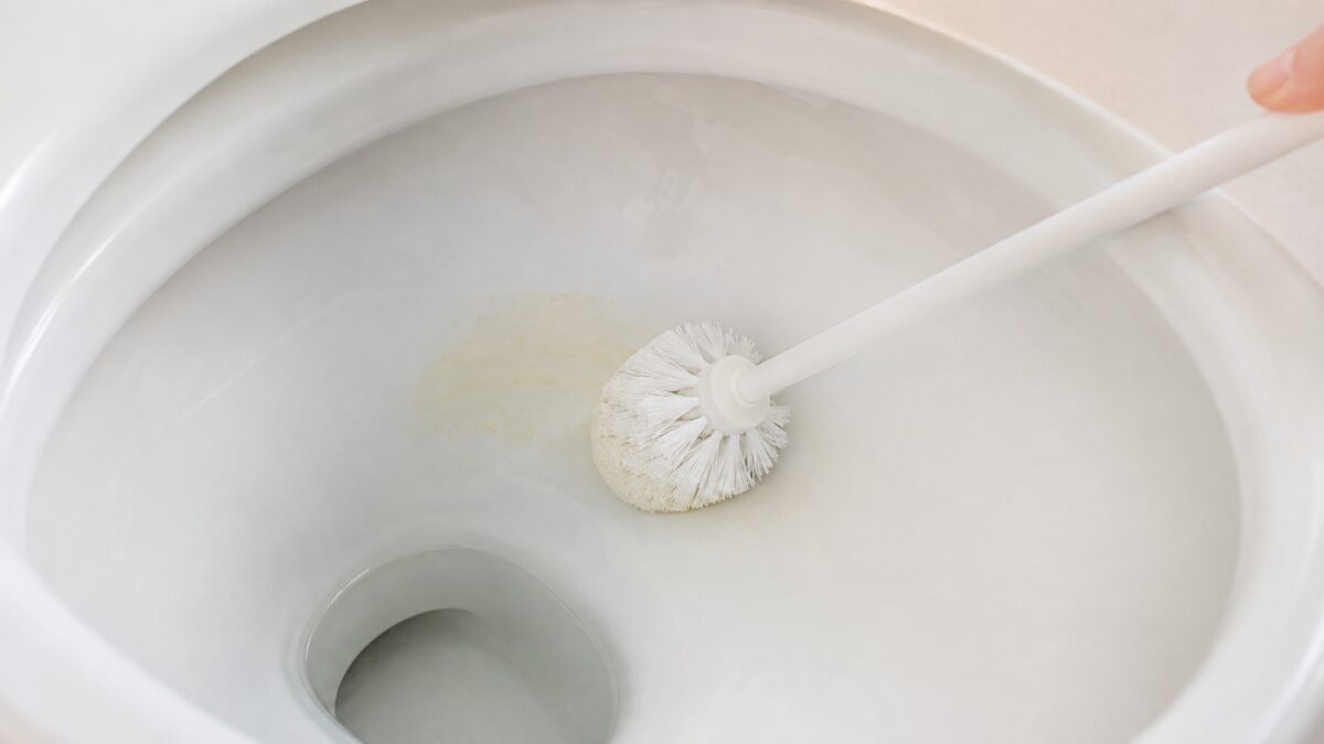トイレ便器内の黄ばみを柔らかい掃除道具で洗う様子